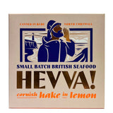 A square 113g box of Hevva! Cornish Hake in Lemon, featuring a vintage-style illustration of a fisherman in a blue hood on a beige background with navy and orange text.