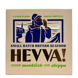 A square 110g box of HEVVA! Cornish Monkfish with Aleppo, featuring a vintage-style illustration of a fisherman in a blue hood on a beige background with green and dark blue text.
