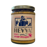 A 450g jar of Hevva Devon Crab Bisque with a gold lid and and illustration of a Cornish Fisherman on the label.