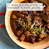 Roni B's Filipino Pork and chicken adobo in a red and beige pot with green onions on a blue background.