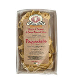 A package of Rustichella d'Abruzzo Dry Egg Pappardelle pasta in a clear plastic tray with a large tan paper label, photographed on a white background.