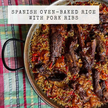 Spanish oven-baked rice with pork ribs in a pan on a plaid tablecloth